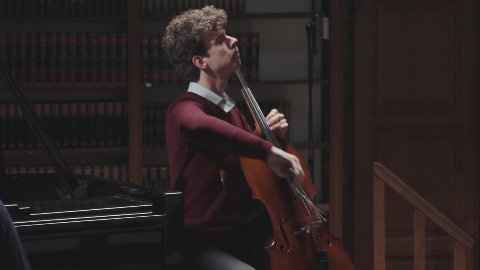 Simon en Daan nemen piano en cello op onder een wenteltrap